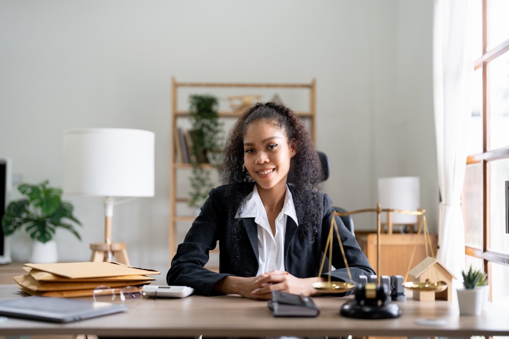 Professionnelle du droit à son bureau, avec dossiers, balance et maillet