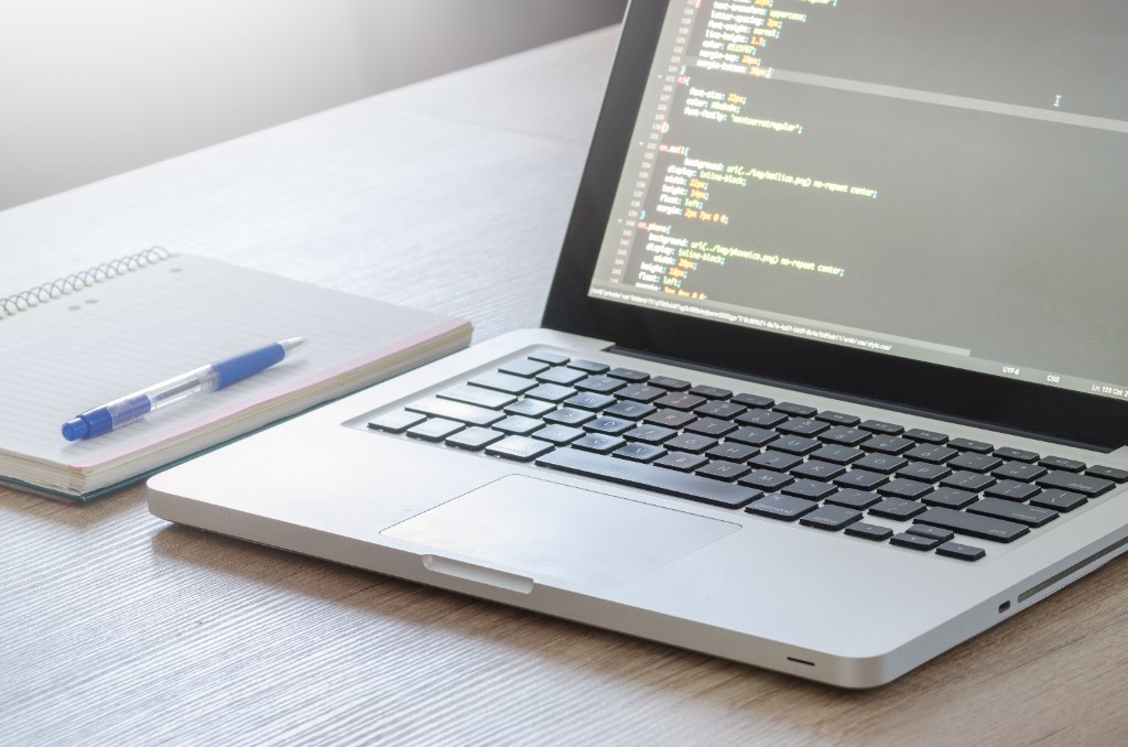 Espace de travail développement SaaS : ordinateur portable et code à l'écran