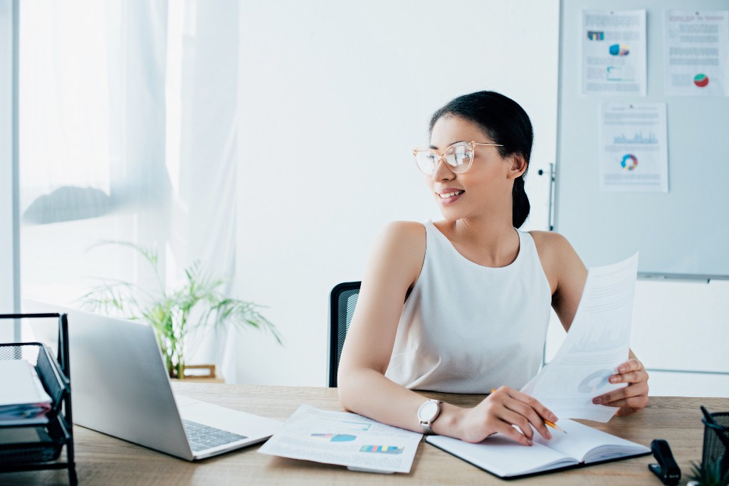 Professionnelle analysant des rapports et graphiques pour un projet CRM